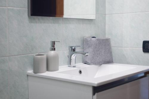 un lavandino in bagno con dispenser di sapone di Flor Thermae&Relax a Montegrotto Terme