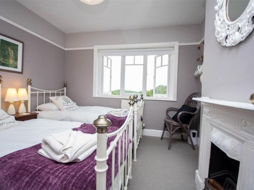 two twin beds in a room with a fireplace at 3 Bed in Studland DC071 in Studland