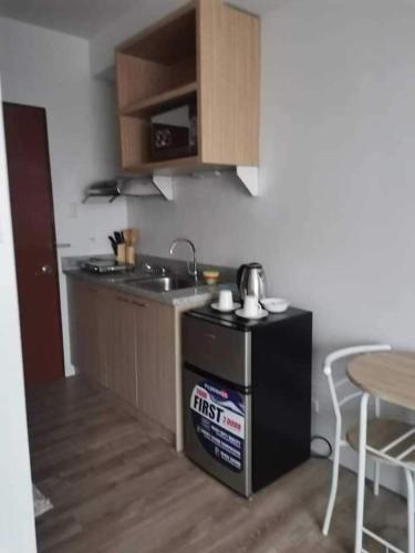 a kitchen with a stove and a sink and a table at Oceanview Condo Bacolod City in Bacolod