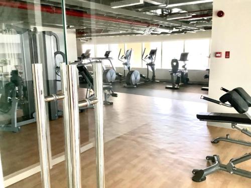 a gym with tread machines and people exercising in the gym at Oceanview Condo Bacolod City in Bacolod