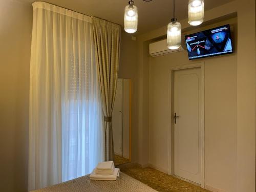 a room with a tv on the wall and a window at Hotel Lukas in Viareggio