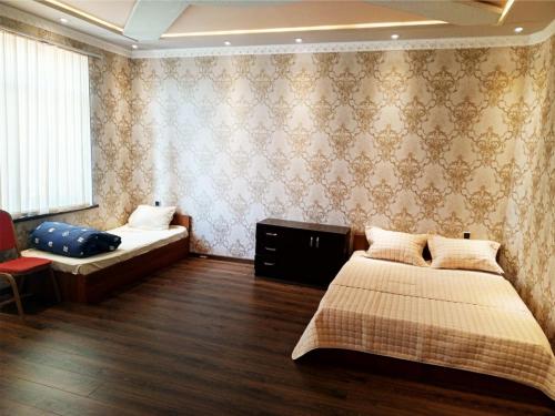 a bedroom with two beds and a window at Temur Hotel in Dushanbe