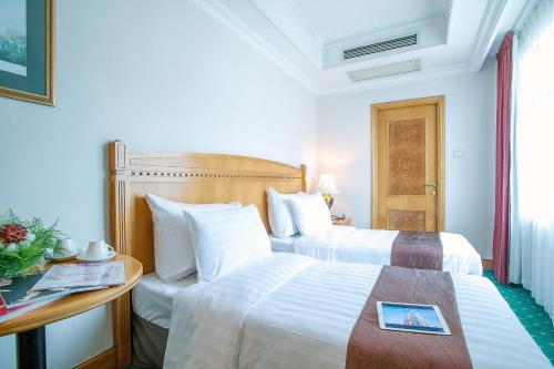 香港にあるBEST WESTERN PLUS Hotel Hong Kongのベッド2台とテーブルがあるホテルの部屋