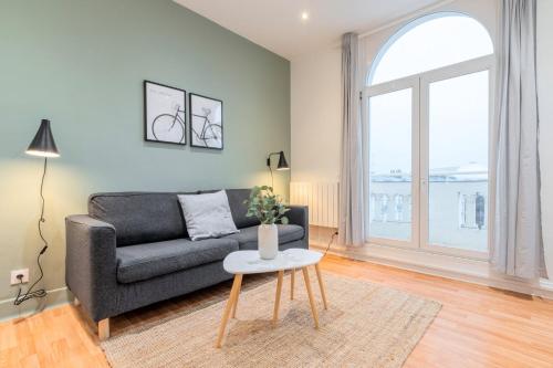 un salon avec un canapé et une table dans l'établissement Apartment for 4 in front of Lille Flandres station, à Lille