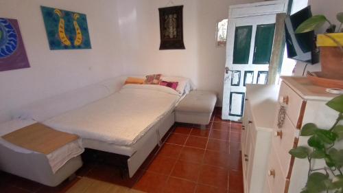 Kleines Zimmer mit einem Bett und einem Tisch in der Unterkunft Finca Azuay - Bikers & climbers refuge in Santa Cruz de Tenerife