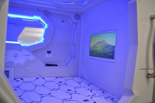 une chambre violette avec une montagne dans l'établissement Cosmos capsule coworking London, à Londres