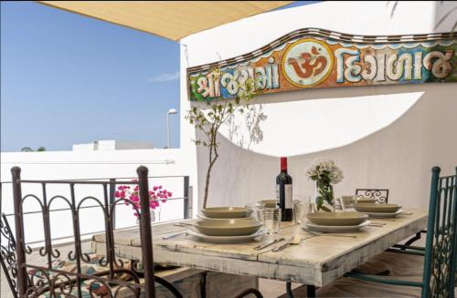 una mesa con platos y una botella de vino en el balcón en Casa Pedro Luis, en Conil de la Frontera