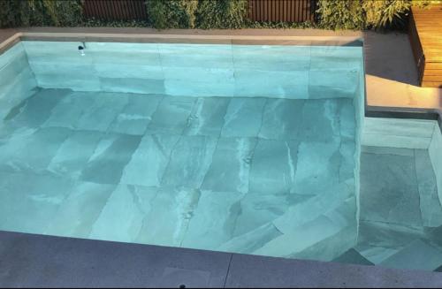 a swimming pool with blue tiles on the ground at Casa Pedro Luis in Conil de la Frontera