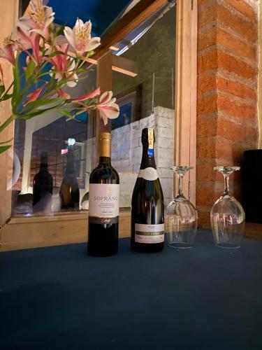 zwei Flaschen Wein auf einem Tisch mit zwei Weingläsern in der Unterkunft Canta La Rana in Quito