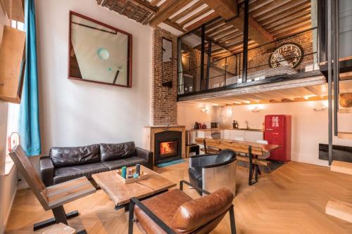 un salon avec un canapé et une cheminée dans l'établissement Duplex d'architecte avec 3 chambres, à Lille
