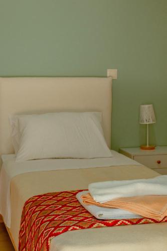a bedroom with a white bed and a night stand with a lamp at Villa Kalamitsi Luxury Villa in Apokorona Chania in Kariá