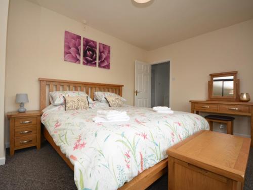 a bedroom with a large bed and a table at 5 bed in Brynteg 75907 in Llanwenog