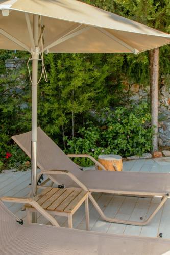 a chair under an umbrella on a deck at Villa Kalamitsi Luxury Villa in Apokorona Chania in Kariá