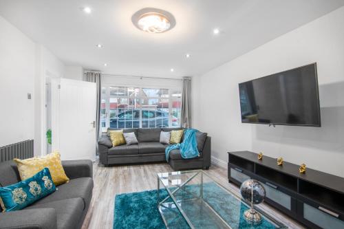 a living room with a couch and a flat screen tv at Gravesend 3 Beds By JADA Homes in Gravesend