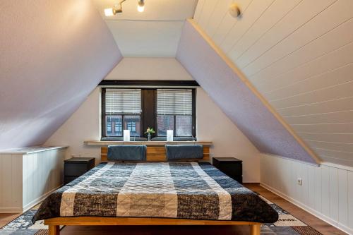 a attic bedroom with a bed and a window at Ferienwohnung Eichkater in Dannau