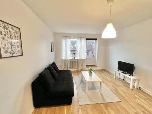 un soggiorno con divano nero e TV di Luxurious Apartment With Lovely View a Göteborg