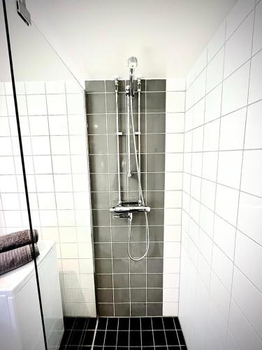 bagno con doccia e piastrelle bianche e nere di Luxurious Apartment With Lovely View a Göteborg