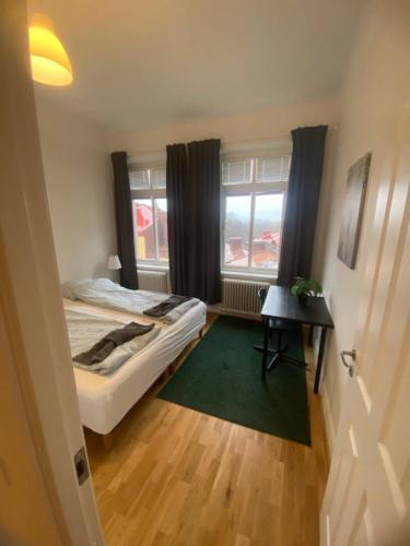 a bedroom with a bed and a table and a window at Modern Apartment In Lovely Part Of The City in Gothenburg