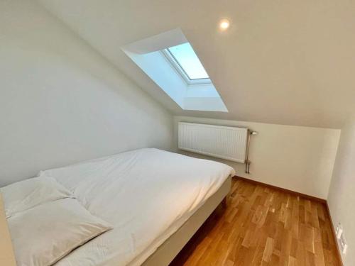 a small bedroom with a bed with a skylight at Cozy Private Terrace Flat In Central Gothenburg in Gothenburg