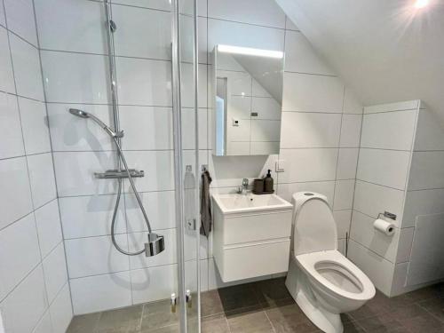 a white bathroom with a shower and a toilet at Cozy Private Terrace Flat In Central Gothenburg in Gothenburg
