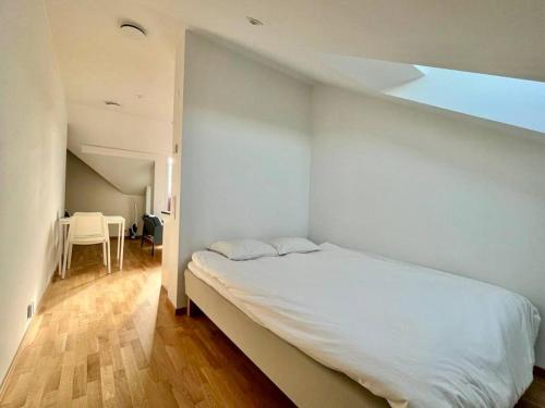 a bedroom with a white bed and a table at Cozy Private Terrace Flat In Central Gothenburg in Gothenburg