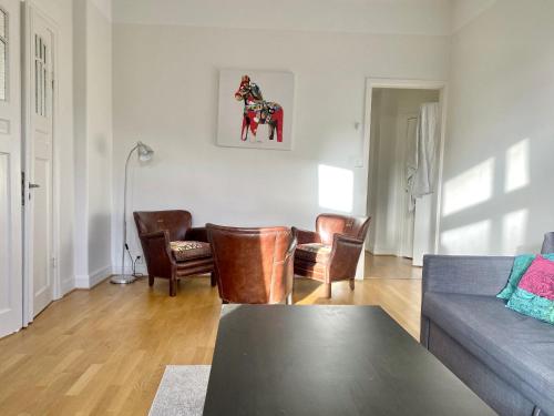 a living room with a couch and a horse picture on the wall at Luxury Apartment In City Centre in Gothenburg