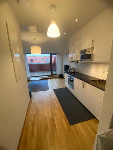 eine Küche mit weißen Schränken und Holzböden in der Unterkunft Luxurious Flat With A Private Rooftop Terrace in Göteborg