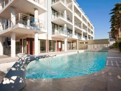 un edificio con piscina en frente de un edificio en Bord de mer! Studio Terrasse ,Prado Plage, en Marsella