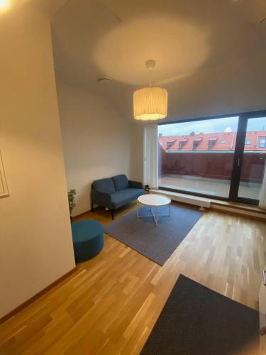 ein Wohnzimmer mit einem blauen Sofa und einem Tisch in der Unterkunft Luxurious Flat With A Private Rooftop Terrace in Göteborg