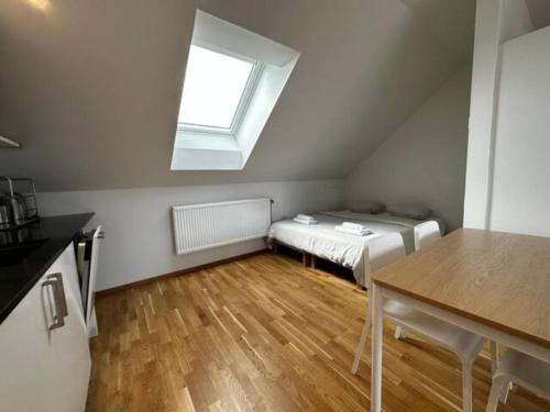 a small attic room with a bed and a window at Luxurious Apartment With Private Terrace in Gothenburg