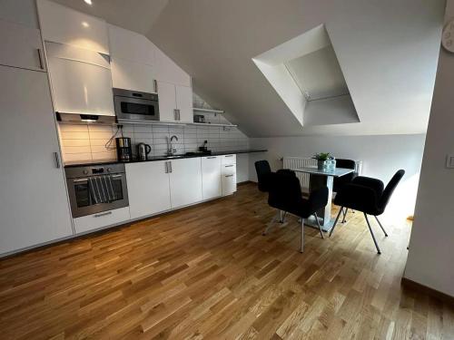 una cucina con armadi bianchi, tavolo e sedie di Luxury Apartment With Private Terrace a Göteborg