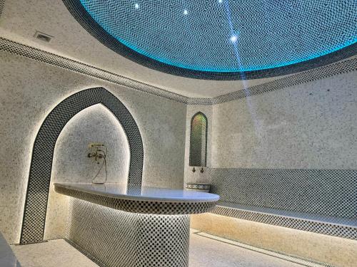 a room with a sink and a blue ceiling at Bentley Hotel Tashkent in Tashkent