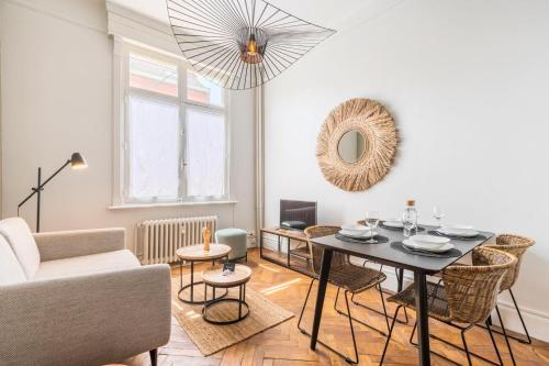 een woonkamer met een tafel en een bank bij Charming and comfortable apartment near tramway in Marcq-en-Baroeul