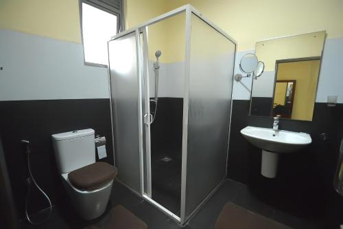 a bathroom with a shower and a toilet and a sink at Gunners Club in Minneriya