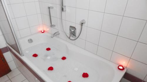 a bath tub with red hearts on it in a bathroom at Hotel Garni Schwane in Meßstetten