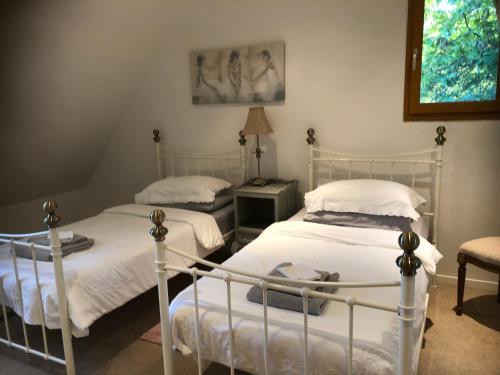 1 dormitorio con 2 camas y mesa con lámpara en Les Jonquilles, en Domme