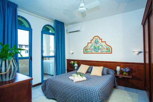 a bedroom with a bed with blue walls and windows at Residenza dei Cavalleggeri in San Vincenzo