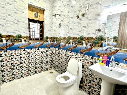 een badkamer met een toilet, een wastafel en stoelen bij 3 BHK entire villa near Medanta hospital in Gurgaon