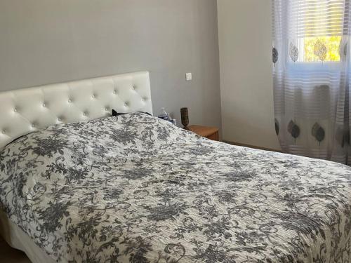- une chambre avec un lit et une couverture noire et blanche dans l'établissement Magnifique villa , piscine ,hamam près des plages, à Pérols