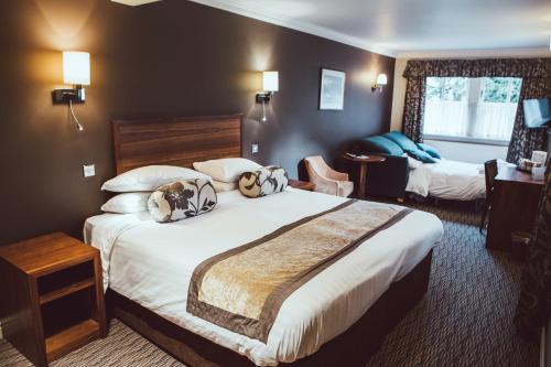 a hotel room with a large bed with pillows at Royal Oak Hotel in Betws-y-coed