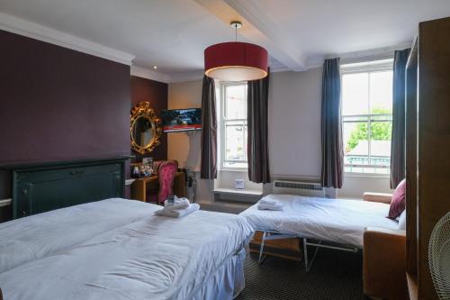 a hotel room with two beds and a window at The Unicorn Hotel Wetherspoon in Ripon