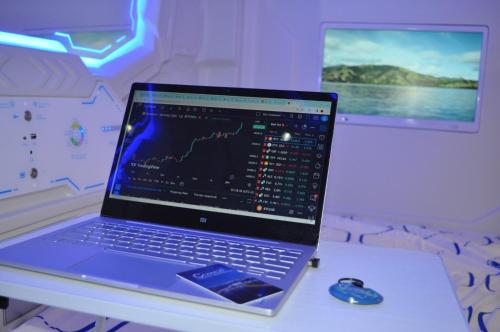 a laptop computer sitting on a desk with a mouse at Cosmos capsule coworking London in London