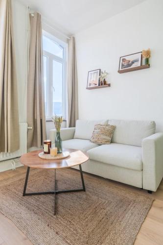 un salon avec un canapé et une table basse dans l'établissement Charming one bedroom Tourcoing station, à Tourcoing