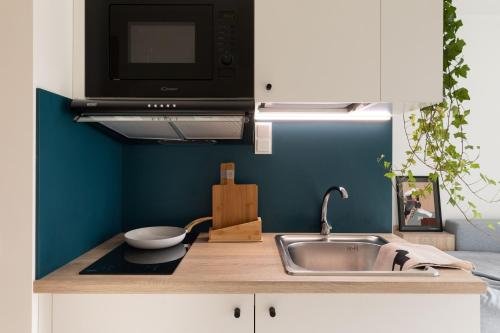 a kitchen with a sink and a microwave at MILESTONE Krakow Center Student Living in Krakow