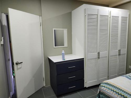 a bedroom with a bed and a dresser with a mirror at Cozy 1-bedroom apartment in Frequente, St. George in Frequente