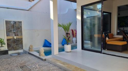 a house with a pool with a living room at Sansari Villa Sanur in Sanur