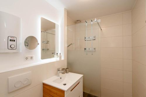y baño blanco con lavabo y ducha. en Alea, en Westerland