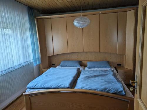 a bedroom with a bed with blue sheets and a light at Ferienhaus Brigitte in Dichtelbach
