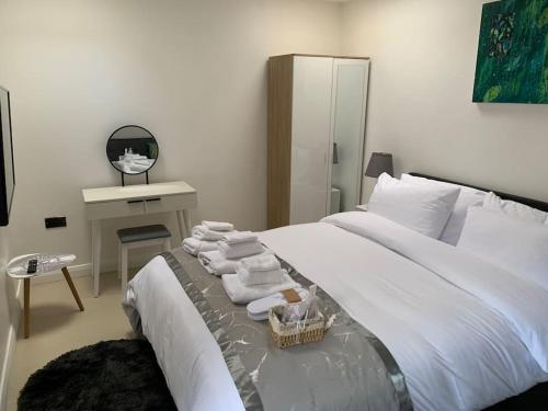 una camera da letto con un grande letto bianco con asciugamani di Annex D. One Bedroom flat in south London a Carshalton