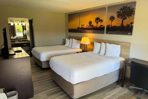 a hotel room with two beds and a television at Days Inn by Wyndham Brooksville in Brooksville